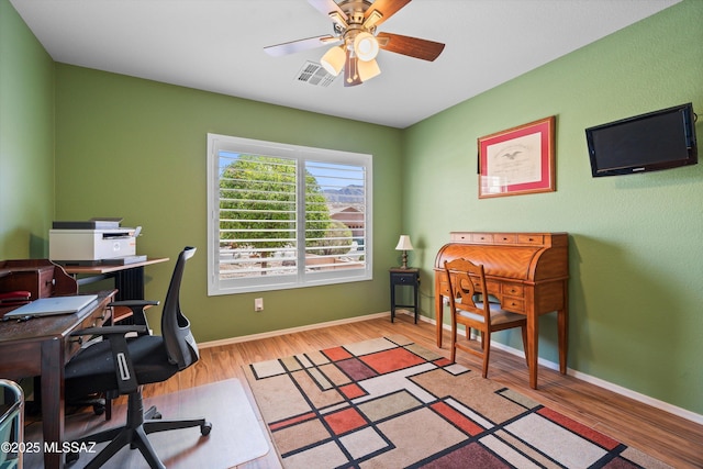 office area with visible vents, baseboards, a ceiling fan, and wood finished floors