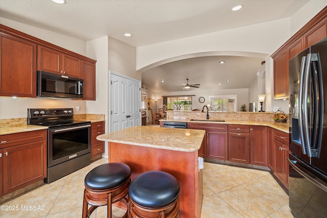 kitchen with fridge with ice dispenser, electric range, a sink, and arched walkways