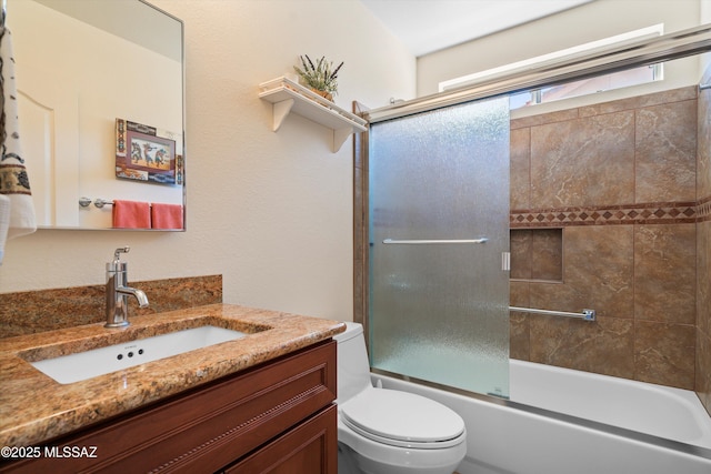 full bathroom featuring toilet, vanity, and shower / bath combination with glass door