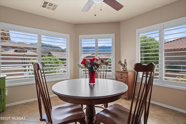 dining room with visible vents, baseboards, a ceiling fan, and light tile patterned flooring