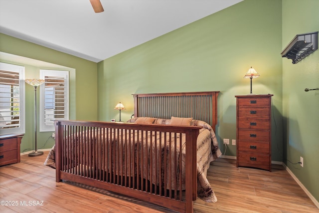 bedroom with light wood-type flooring, baseboards, and a ceiling fan
