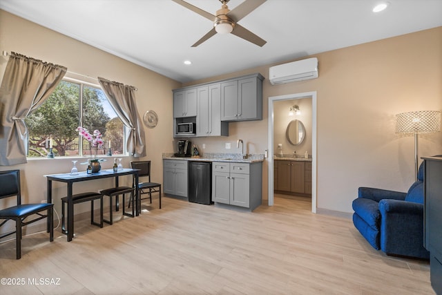 kitchen featuring stainless steel microwave, gray cabinetry, an AC wall unit, and ceiling fan