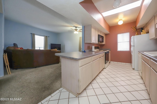 kitchen with electric range, black microwave, a healthy amount of sunlight, and open floor plan