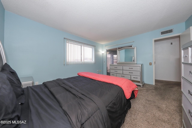 bedroom featuring a textured ceiling, carpet floors, and visible vents