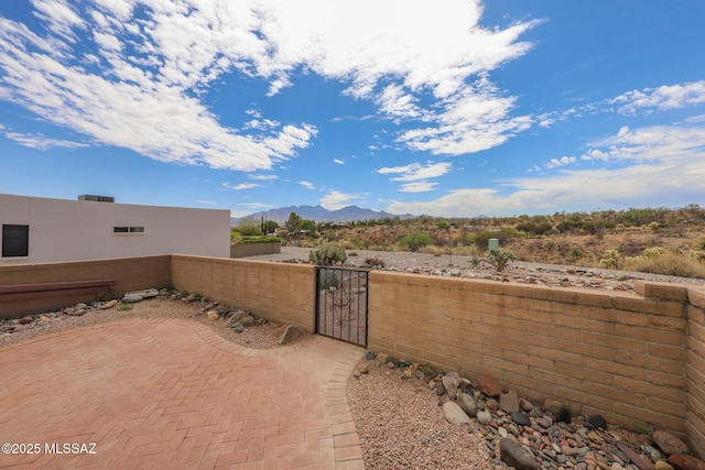 view of patio with a gate, a mountain view, and fence private yard
