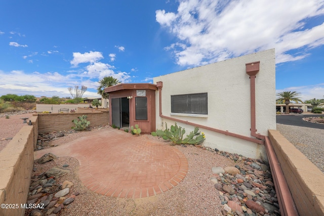 back of house with fence, a patio, and stucco siding