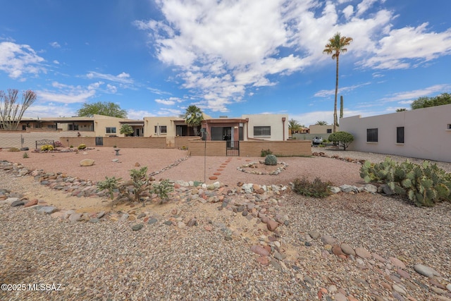 view of front of house featuring stucco siding and fence