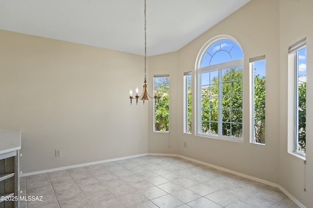 unfurnished dining area with a chandelier, plenty of natural light, light tile patterned floors, and baseboards