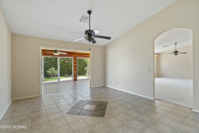 spare room featuring lofted ceiling, visible vents, light tile patterned floors, and ceiling fan