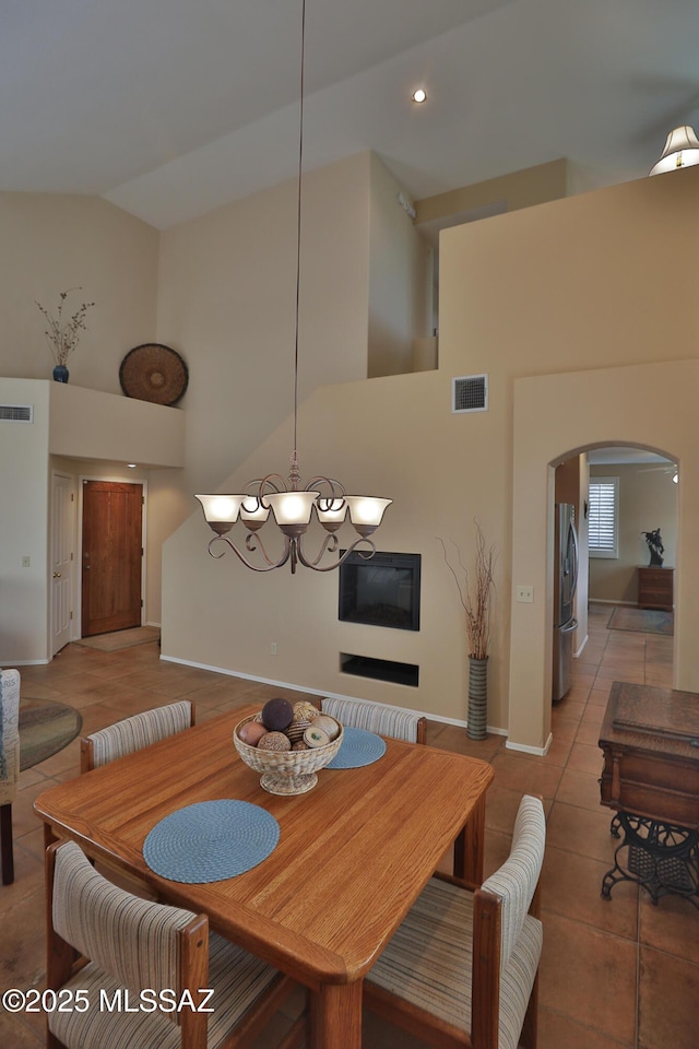 5200 E Calle Vista De Colores, Tucson, AZ 85711 - dining area featuring high vaulted ceiling, arched walkways, light tile patterned flooring, baseboards, and a chandelier