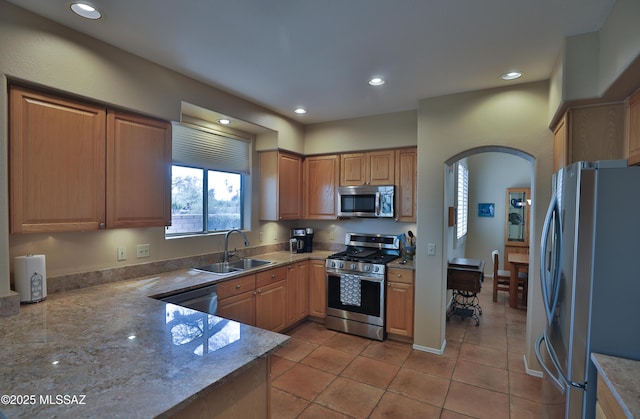 5200 E Calle Vista De Colores, Tucson, AZ 85711 - kitchen featuring appliances with stainless steel finishes, a sink, arched walkways, light stone countertops, and recessed lighting