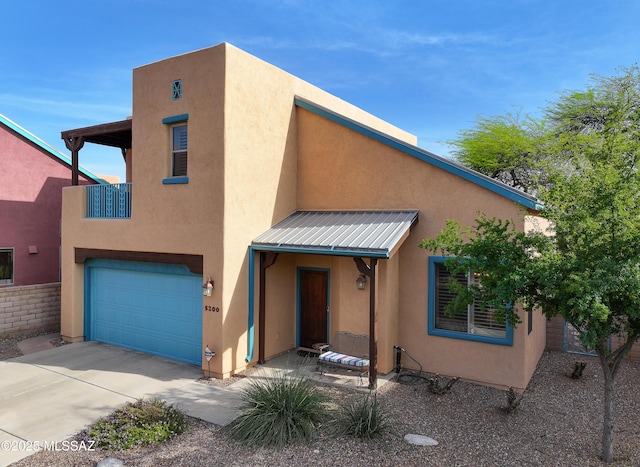 5200 E Calle Vista De Colores, Tucson, AZ 85711 - pueblo-style house featuring a garage, stucco siding, concrete driveway, and metal roof