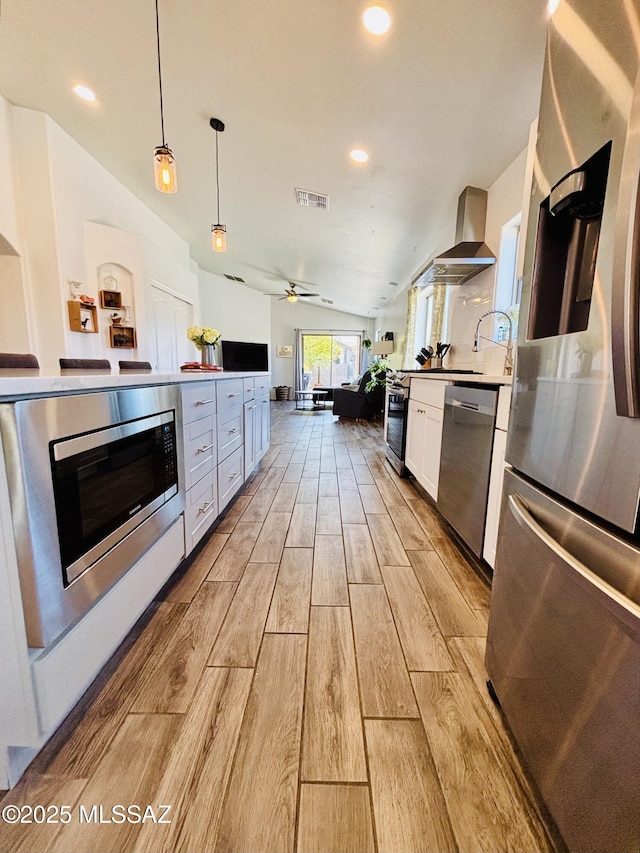 8332 S Otis Dr, Tucson, AZ 85747 - kitchen featuring a healthy amount of sunlight, stainless steel appliances, visible vents, and wall chimney exhaust hood