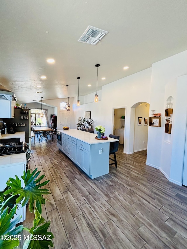 8332 S Otis Dr, Tucson, AZ 85747 - kitchen featuring visible vents, a sink, wall chimney exhaust hood, a kitchen island, and stainless steel appliances