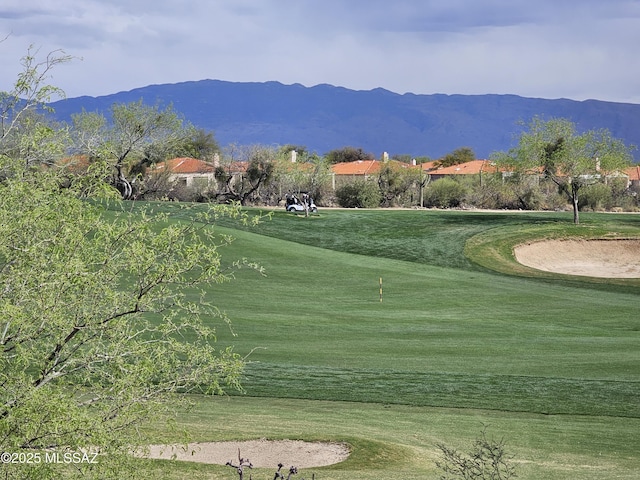 surrounding community with a lawn, view of golf course, and a mountain view