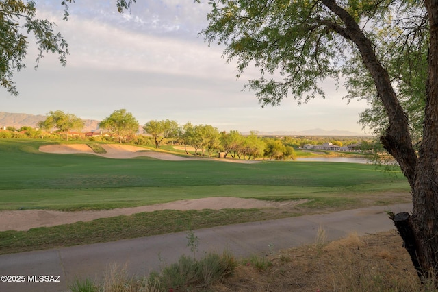 surrounding community with view of golf course, a water view, and a yard
