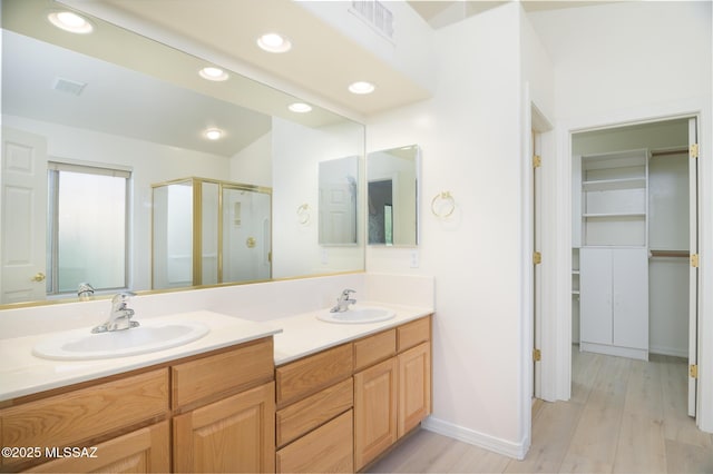 bathroom with double vanity, visible vents, a shower stall, and a sink