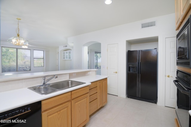 kitchen with visible vents, arched walkways, a sink, light countertops, and black appliances