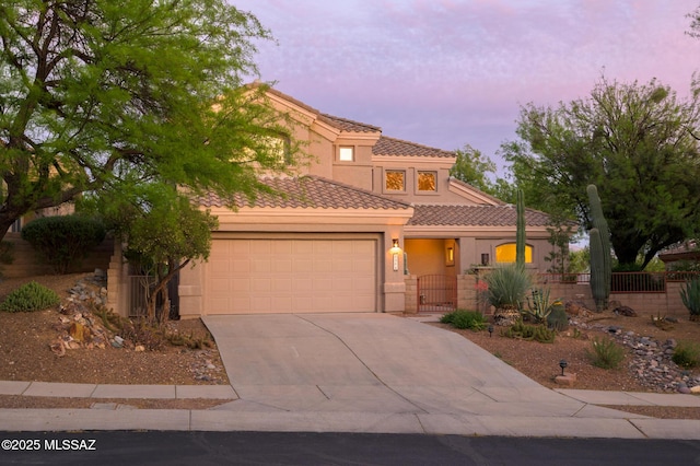 view of front facade with fence, an attached garage, concrete driveway, and stucco siding