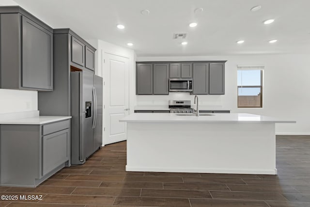 kitchen with gray cabinets, wood finish floors, visible vents, and stainless steel appliances