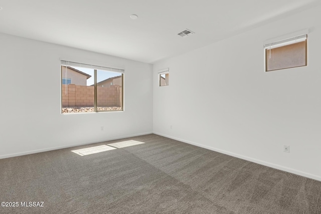 spare room with carpet floors, baseboards, and visible vents