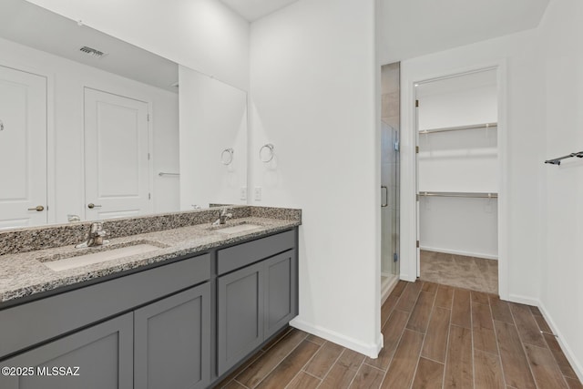 full bathroom featuring baseboards, a sink, and wood tiled floor