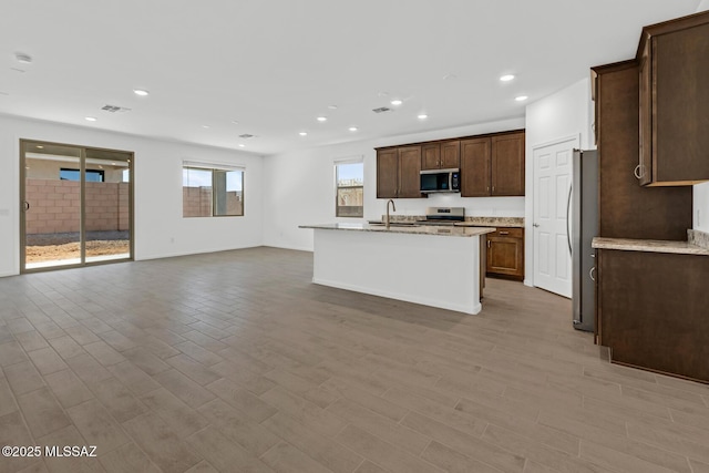 kitchen with visible vents, a sink, open floor plan, recessed lighting, and stainless steel appliances
