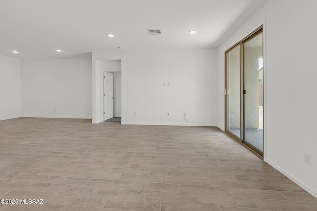 empty room with recessed lighting, light wood finished floors, visible vents, and baseboards