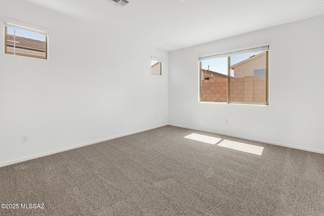 carpeted empty room featuring visible vents and baseboards