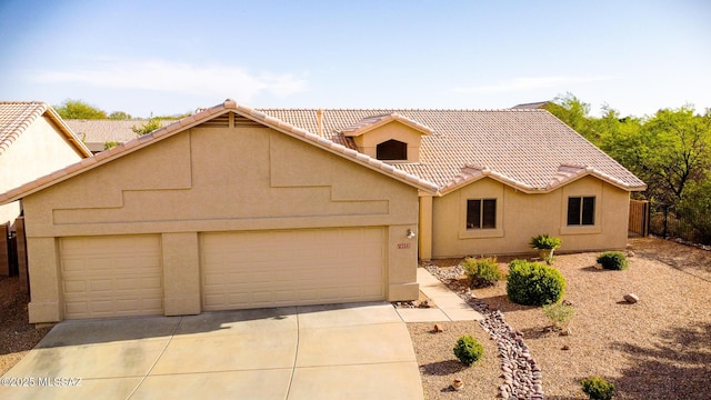 10532 E Malta St, Tucson, AZ 85747 - view of front of house featuring a garage, concrete driveway, a tiled roof, and stucco siding
