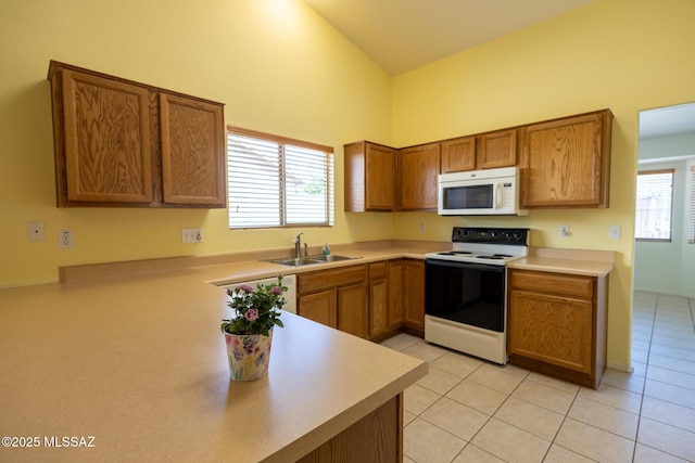10532 E Malta St, Tucson, AZ 85747 - kitchen with white microwave, range with electric stovetop, a sink, brown cabinets, and a towering ceiling