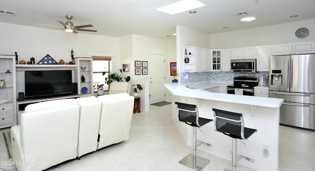 living area with a ceiling fan, visible vents, light tile patterned floors, and recessed lighting