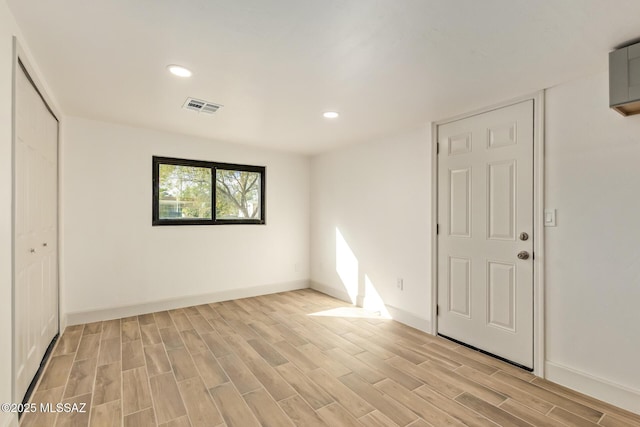 spare room with light wood-type flooring, baseboards, visible vents, and recessed lighting