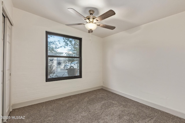 carpeted empty room featuring baseboards and a ceiling fan