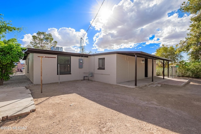 back of property with a patio area, concrete block siding, fence, and central AC