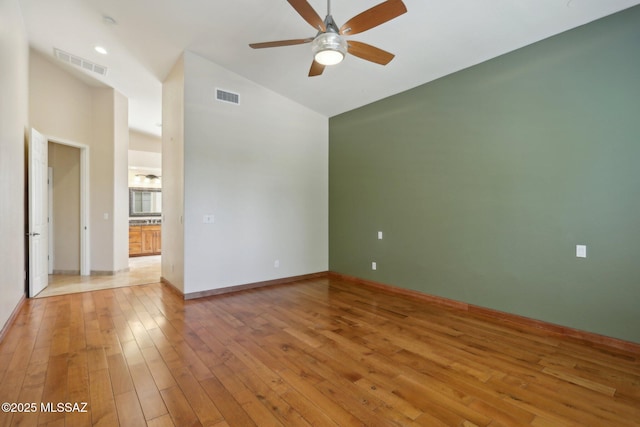 spare room featuring visible vents, baseboards, a ceiling fan, and light wood-style flooring