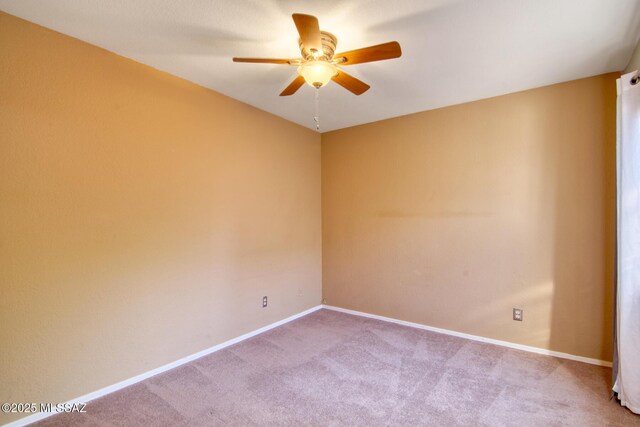 carpeted spare room with baseboards and ceiling fan