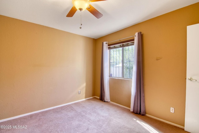 spare room featuring baseboards, ceiling fan, and carpet