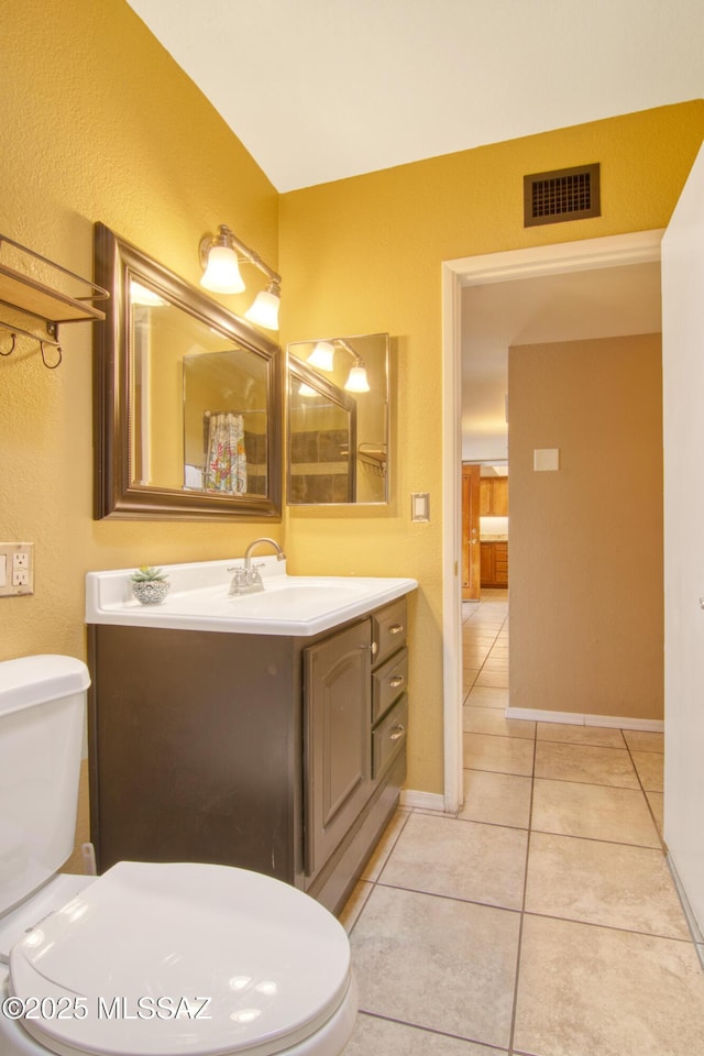 bathroom with visible vents, baseboards, toilet, vanity, and tile patterned flooring