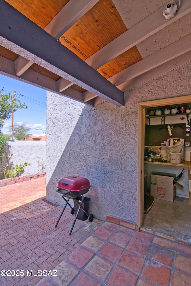 view of patio with area for grilling and fence