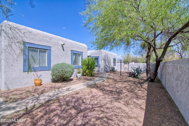 exterior space with stucco siding and fence