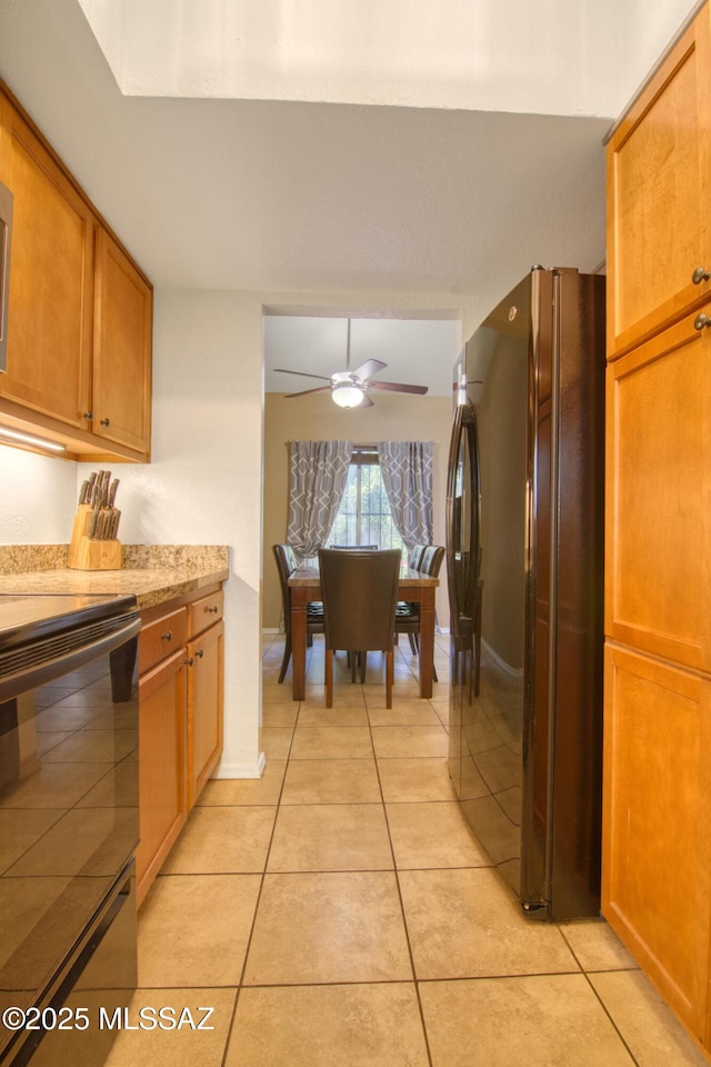 kitchen featuring light countertops, a ceiling fan, black appliances, brown cabinetry, and light tile patterned floors