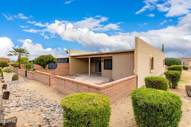 back of property featuring fence and a patio area