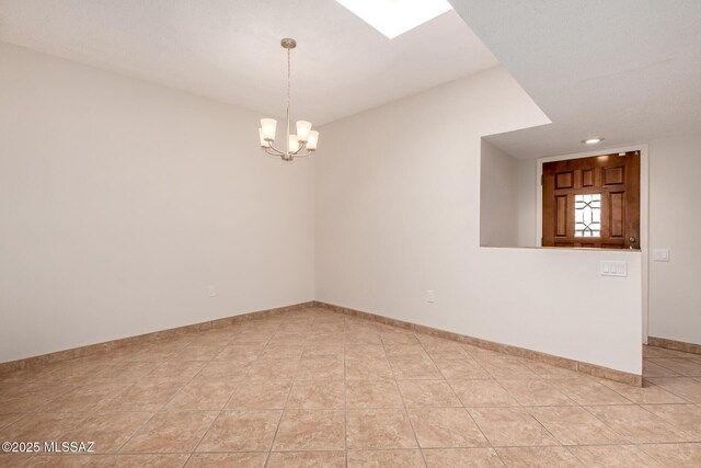 unfurnished room with an inviting chandelier, light tile patterned flooring, and baseboards