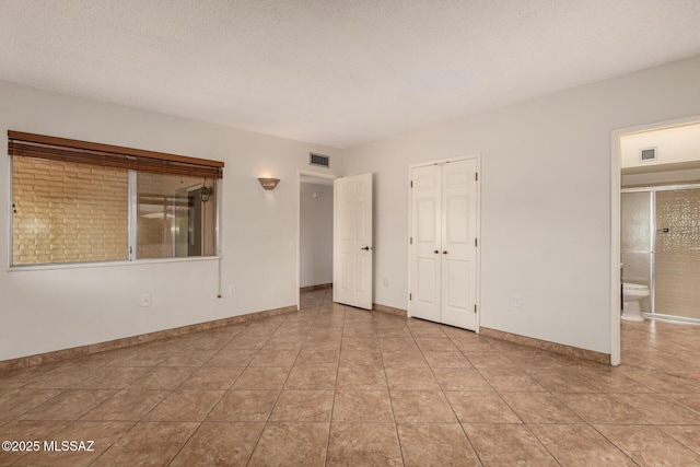 empty room featuring light tile patterned floors, baseboards, and visible vents