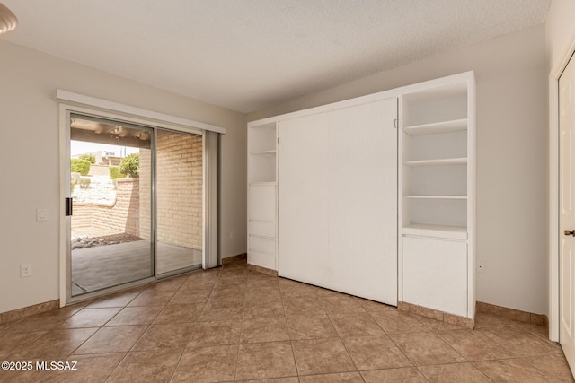 unfurnished bedroom featuring access to exterior and a textured ceiling