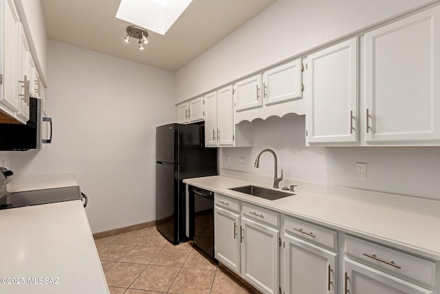 kitchen with light countertops, a skylight, white cabinetry, a sink, and black appliances