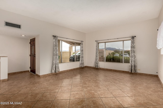 spare room featuring light tile patterned floors, baseboards, and visible vents