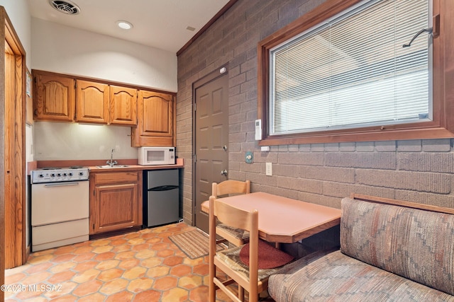 kitchen featuring recessed lighting, a sink, white appliances, visible vents, and light countertops
