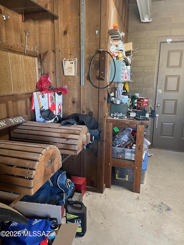misc room featuring concrete flooring and wooden walls